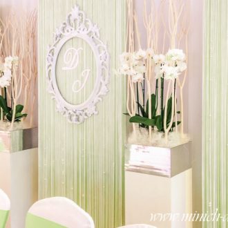 Brauttischhintergrund grün, Deko-Säulen, weiße Orchideen, Ornamentrahmen mit Initialen